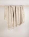 Beige throw blanket with fringes. Beige colour