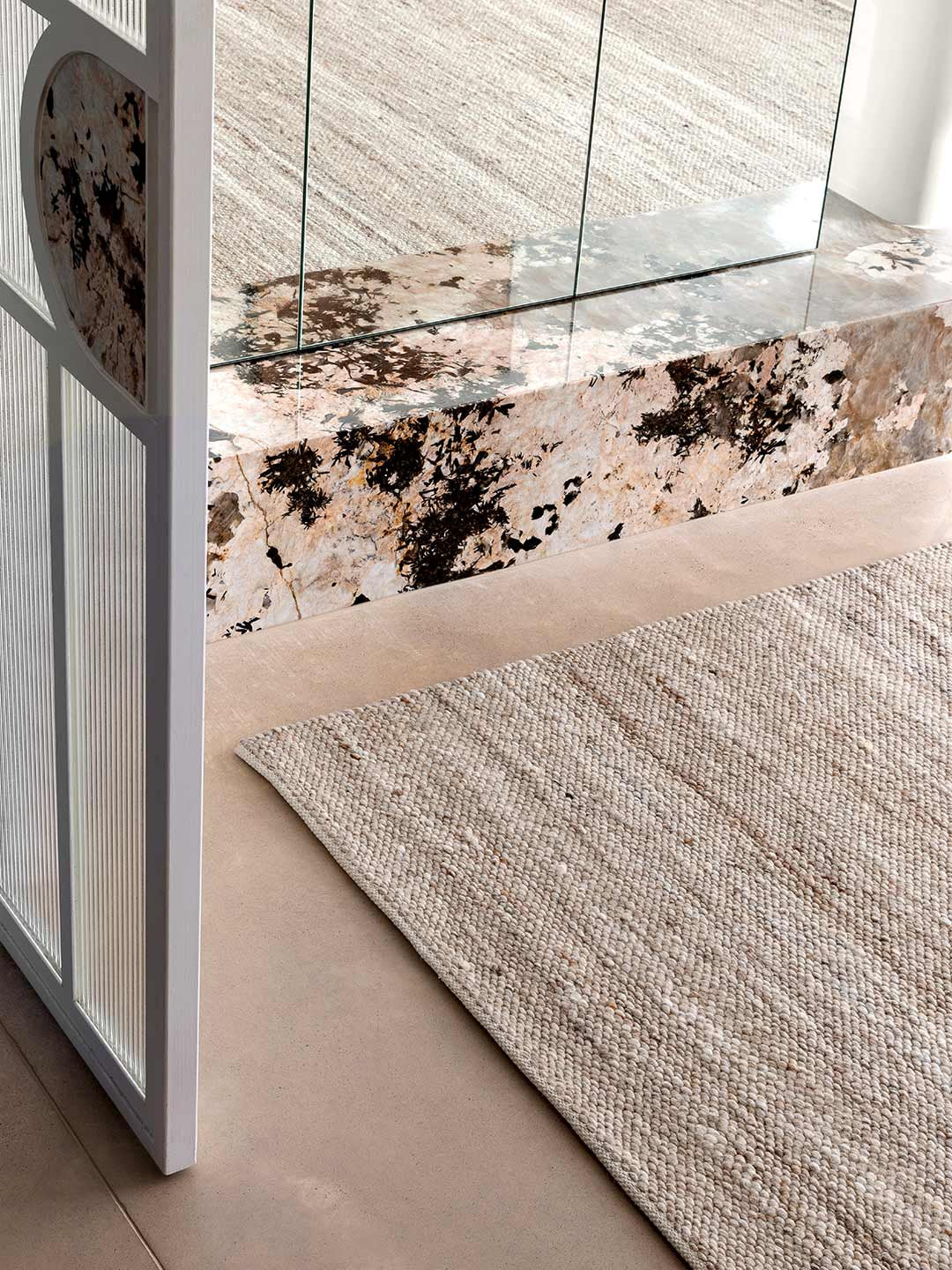 Textured rug on a floor in a warm beige colour palette