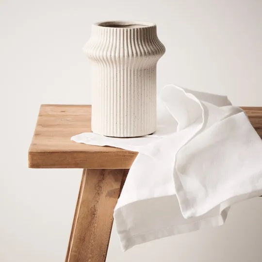 Gili is a shorter ivory coloured linear vase, with its compact design, radiates contemporary charm. Its modest height adds versatility, making it an ideal vessel for smaller arrangements. Ribbed detail and ivory colour.