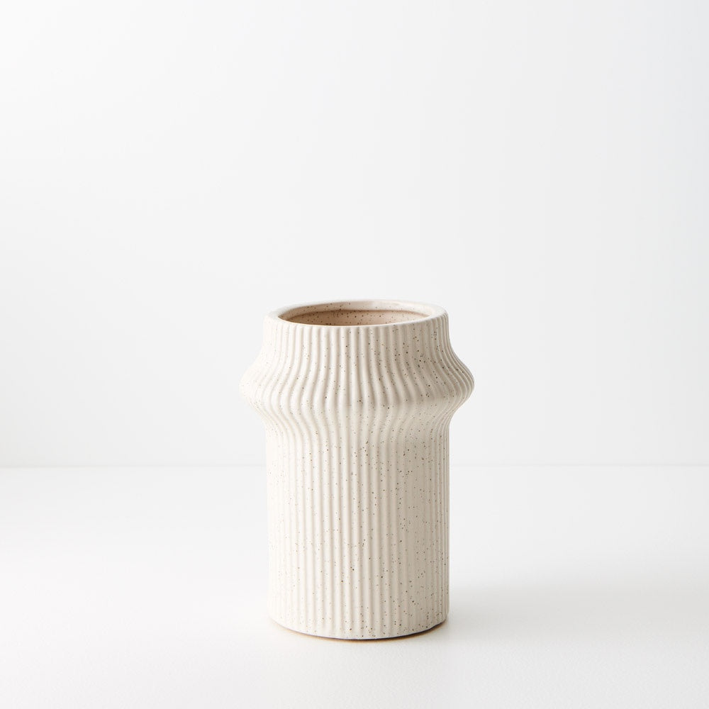 Gili is a shorter ivory coloured linear vase, with its compact design, radiates contemporary charm. Its modest height adds versatility, making it an ideal vessel for smaller arrangements. Ribbed detail.Ivory Colour.
