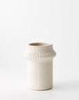 Gili is a shorter ivory coloured linear vase, with its compact design, radiates contemporary charm. Its modest height adds versatility, making it an ideal vessel for smaller arrangements. Ribbed detail.Ivory Colour.