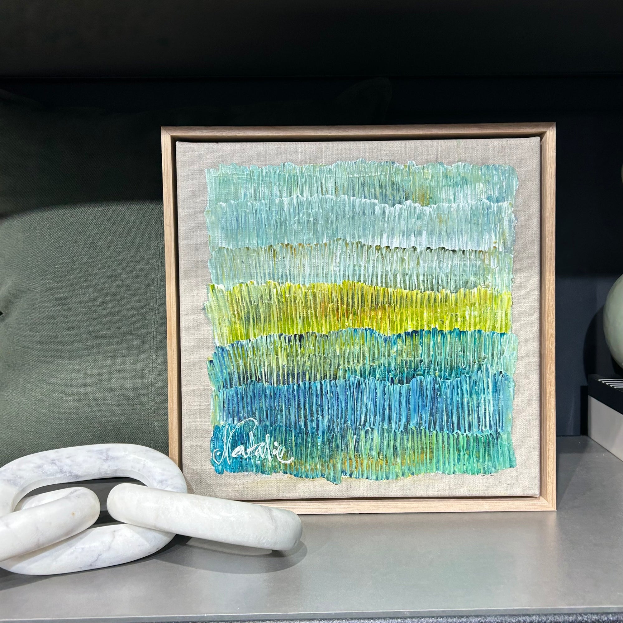 Original artwork by natalie Uhrik measuring 30cm square.  Framed in tasmanian oak frame. textural and featuring a colour palette of blue and greens with hues of gold