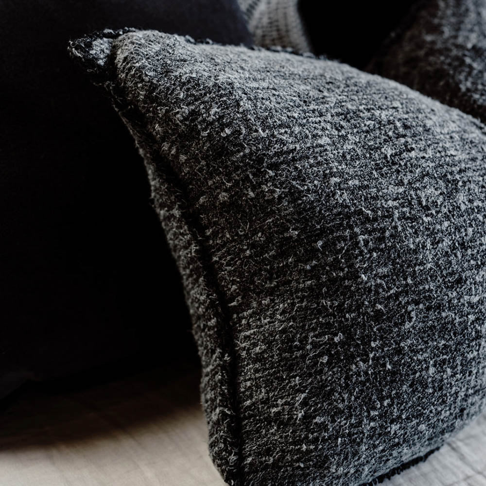 The Sora cushion named after the Japanese word for "sky," captures the beauty of the midnight sky with a blend of deep blue tones and off-white yarns.