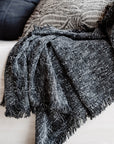 The Sora Throw, named after the Japanese word for "sky," captures the beauty of the midnight sky with a blend of deep blue tones and off-white yarns.