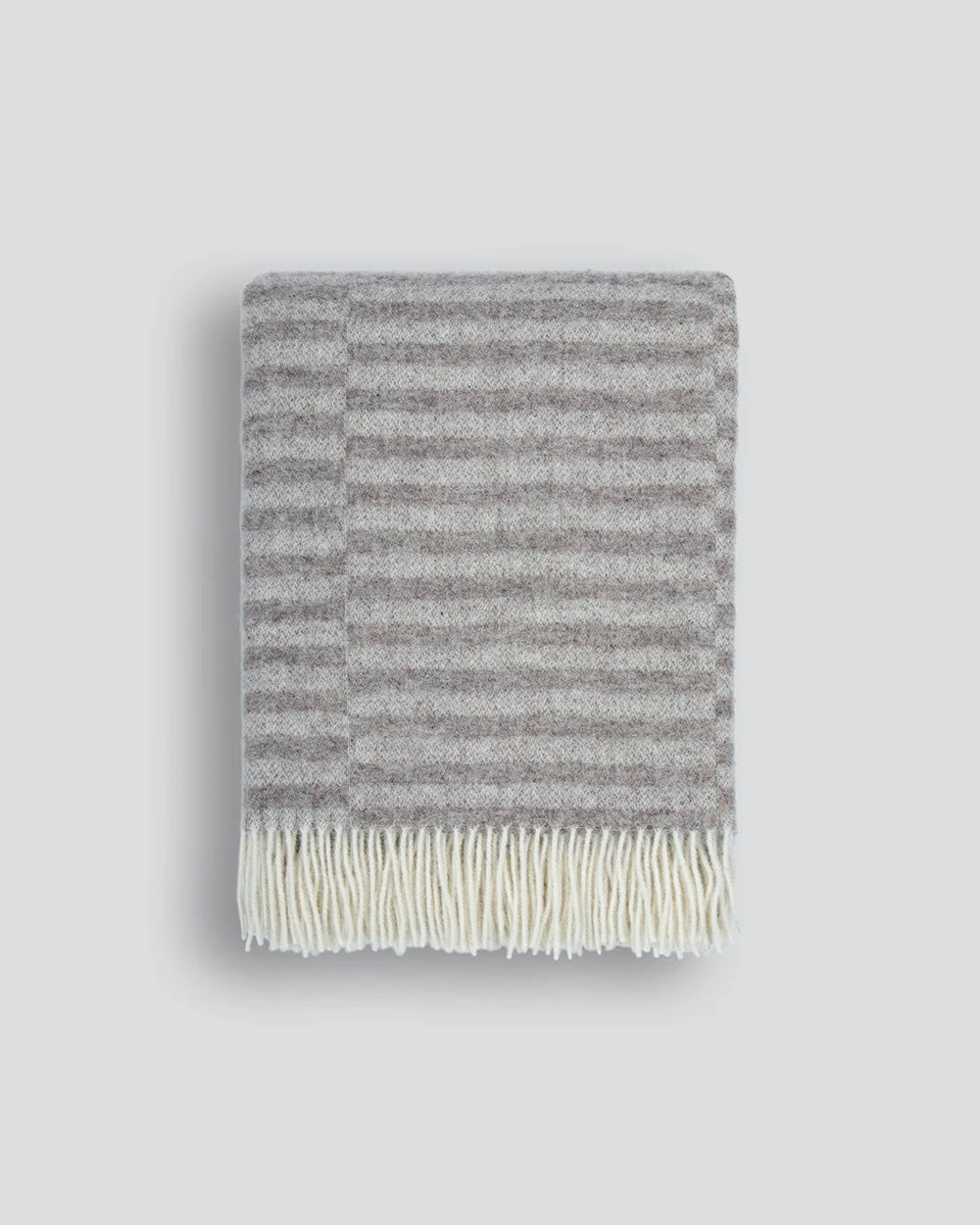 Gray striped blanket with white fringe on a light gray background