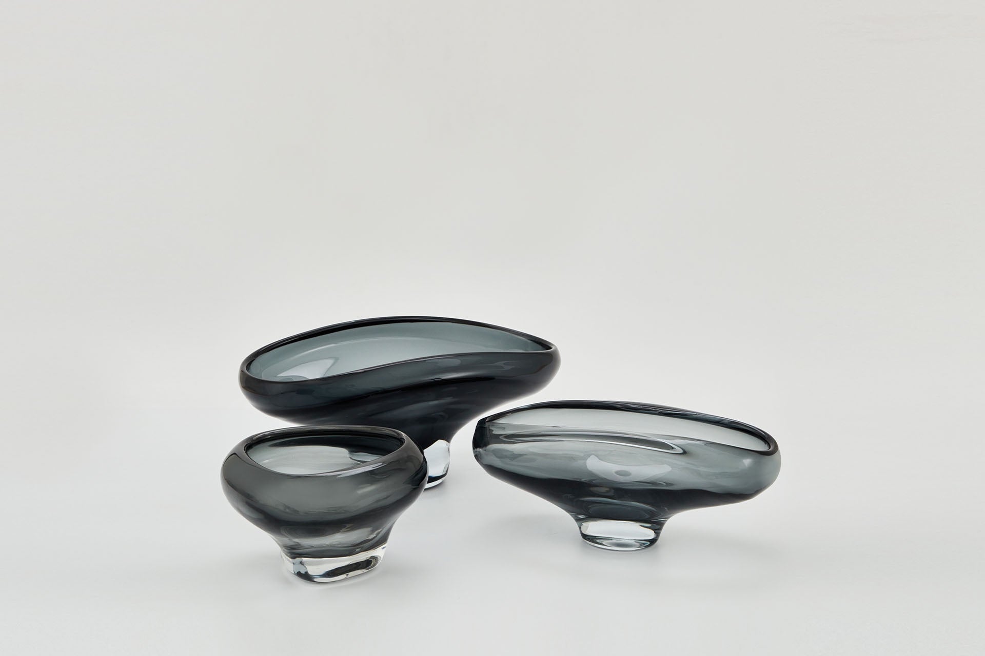 Hand blown and hand finished glass bowl. Mouth-blown from solid glass, each design features unique twists and curves reminiscent of cascading liquid