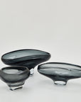 Hand blown and hand finished glass bowl. Mouth-blown from solid glass, each design features unique twists and curves reminiscent of cascading liquid