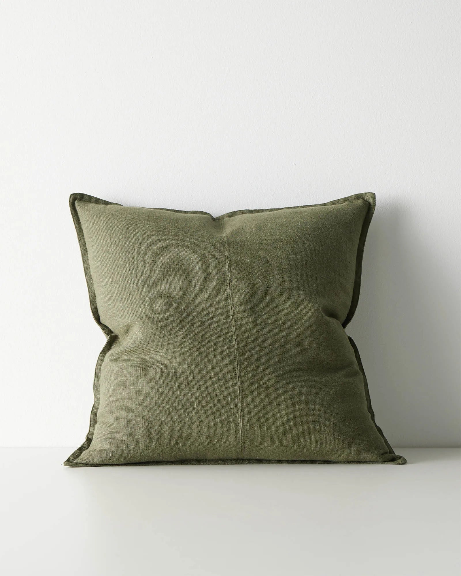 Green linen cushion with flanged edge detail.