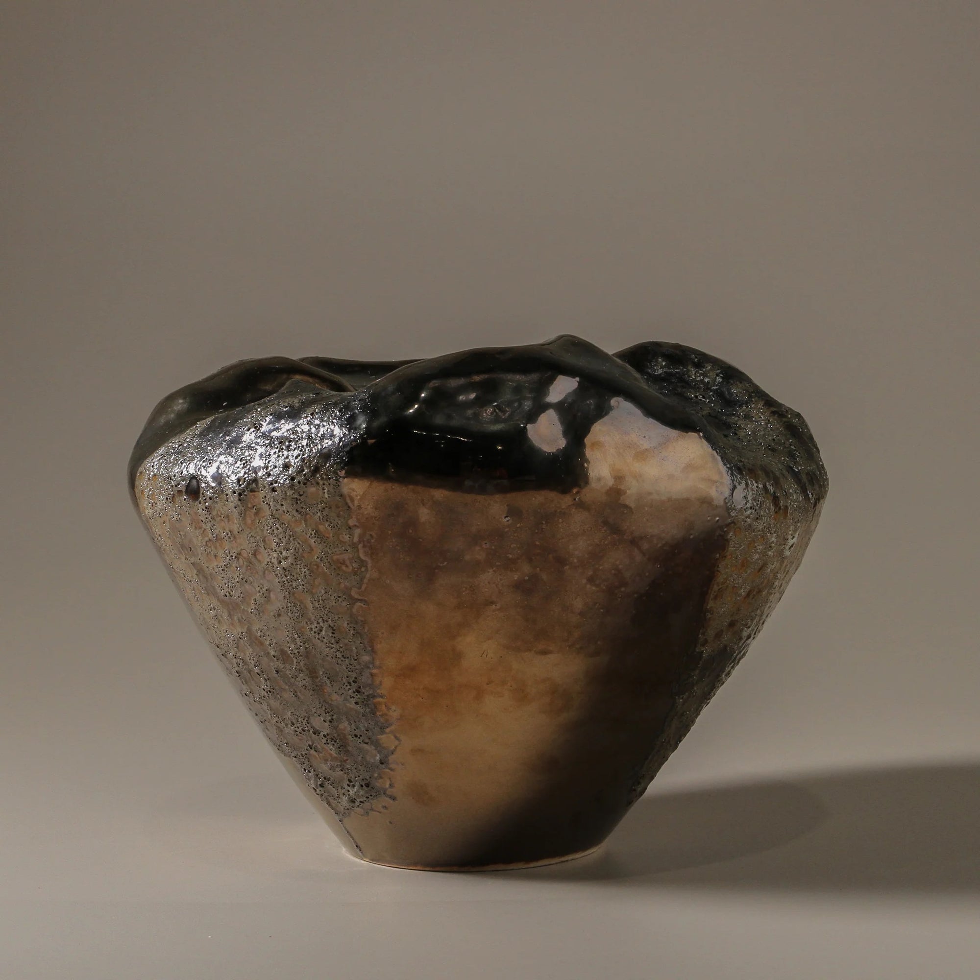 Ceramic vase with textured surface in metallic tone.