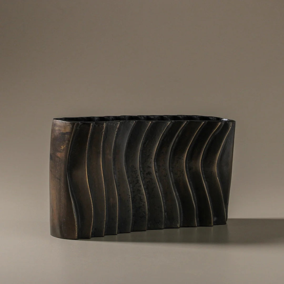 Decorative vase with wavy design on a neutral background