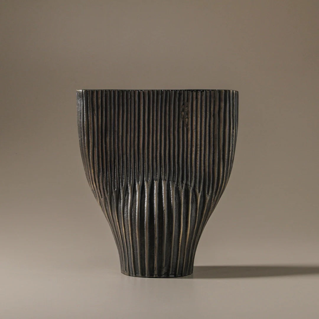 Dark wooden vase with textured surface on a beige background