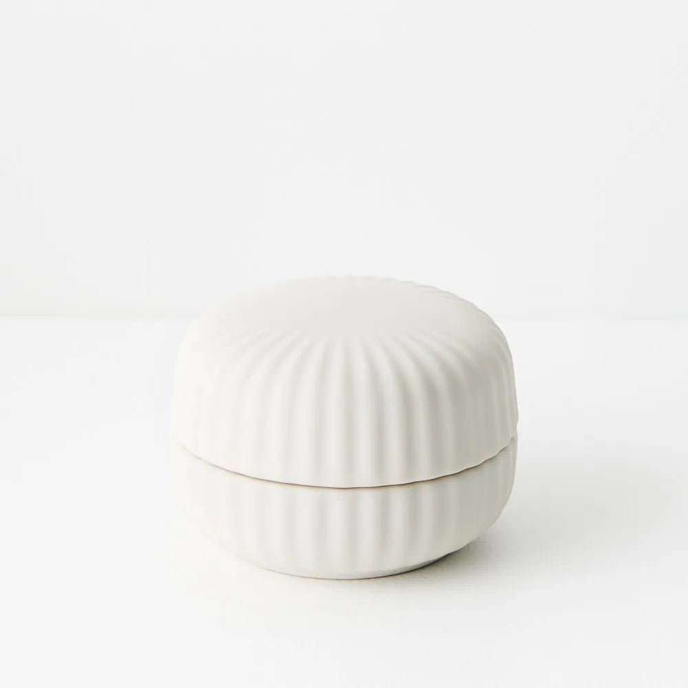White ceramic candle container with ribbed texture 