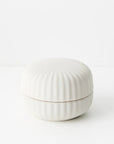 White ceramic candle container with ribbed texture 