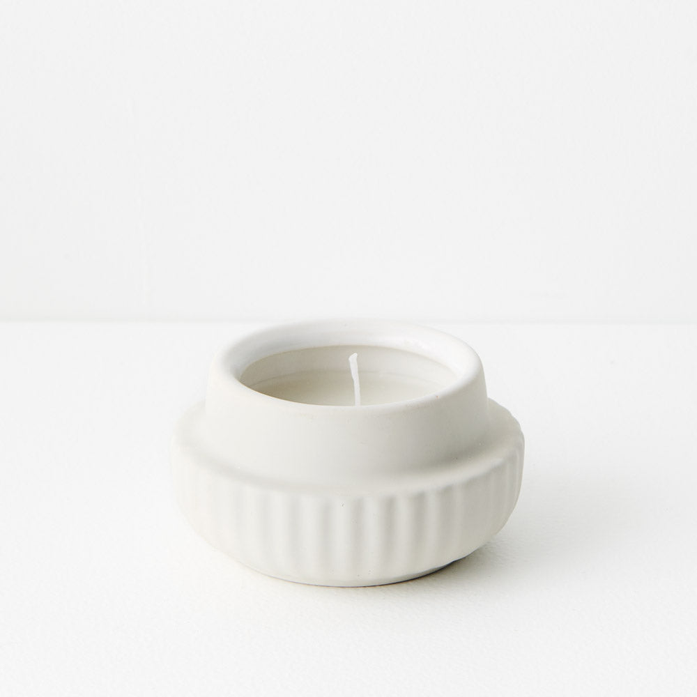 White ceramic candle holder with a candle 