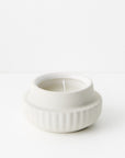 White ceramic candle holder with a candle 