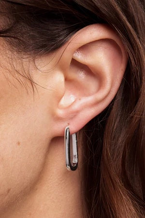 Close-up of an ear wearing a silver hoop earring.