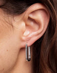 Close-up of an ear wearing a silver hoop earring.