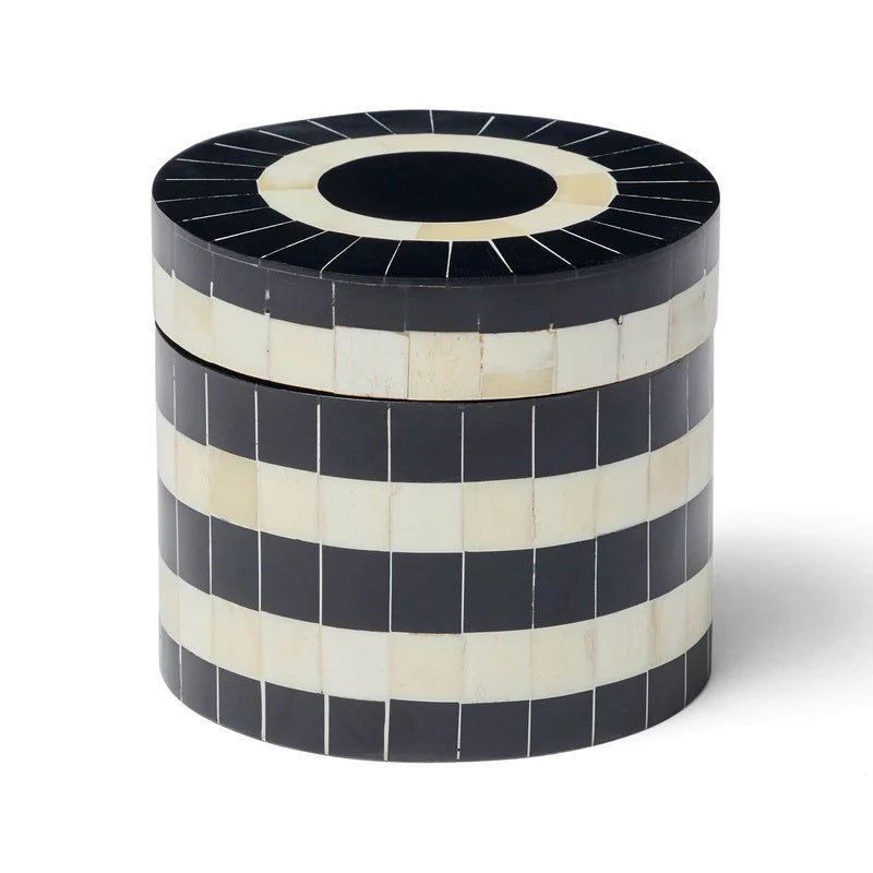 Round decorative box with black and white striped pattern.