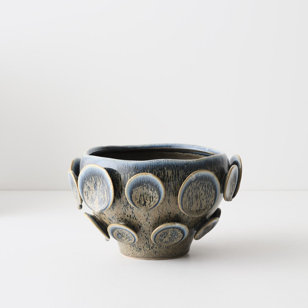 Ceramic bowl with circular patterns. blue green glaze.