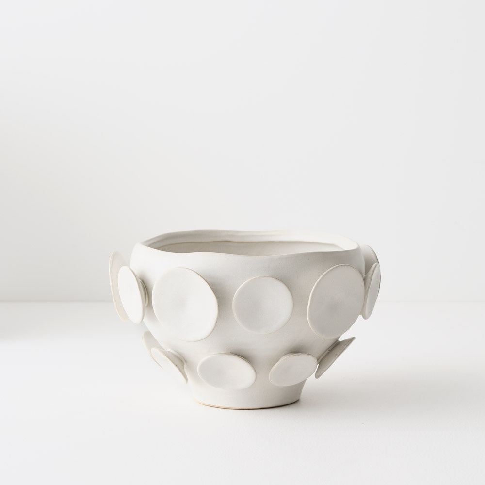 White ceramic bowl with circular patterns.
