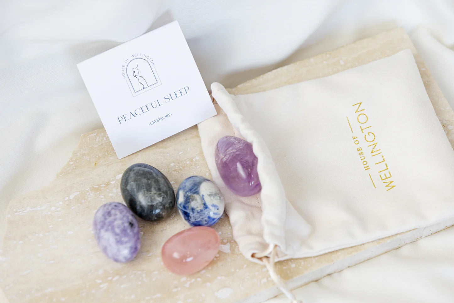 Set of stones with a card labeled 'Peaceful Sleep' with a white drawstring pouch
