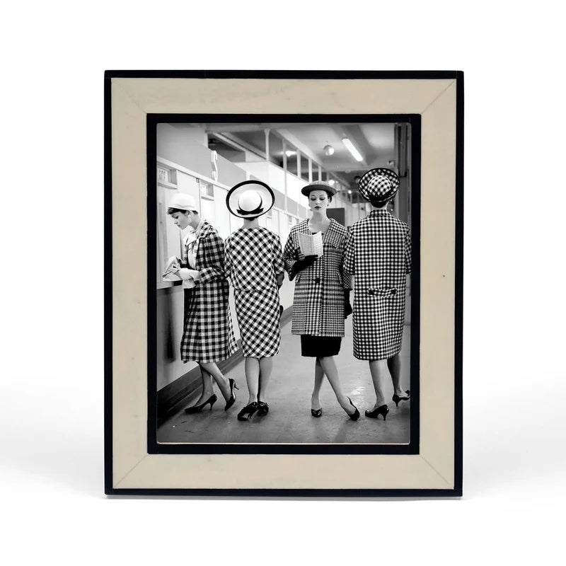 Framed black and white photo of four women in checkered outfits in a store.