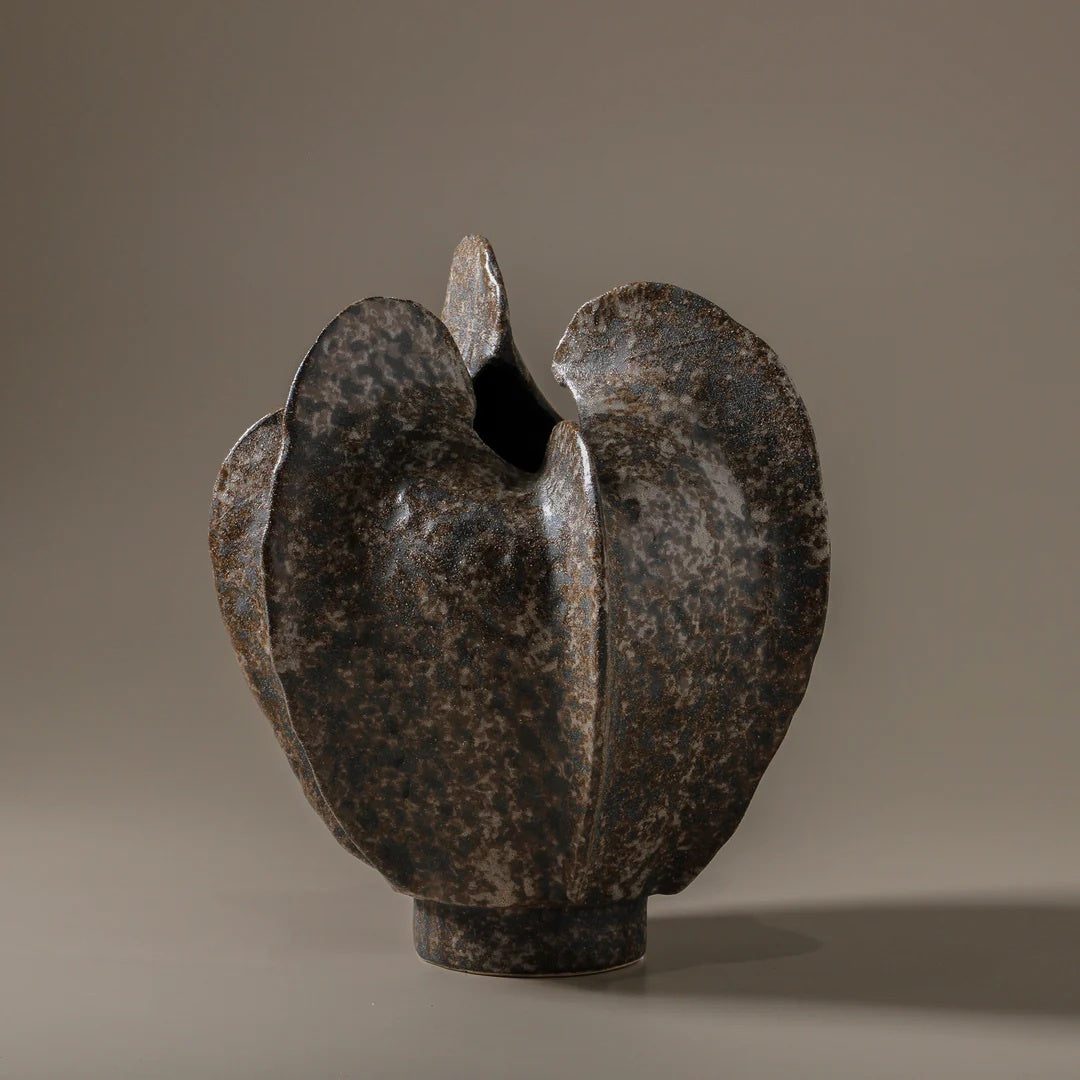 Abstract metallic sculpture on a gray background. Made from ceramic
