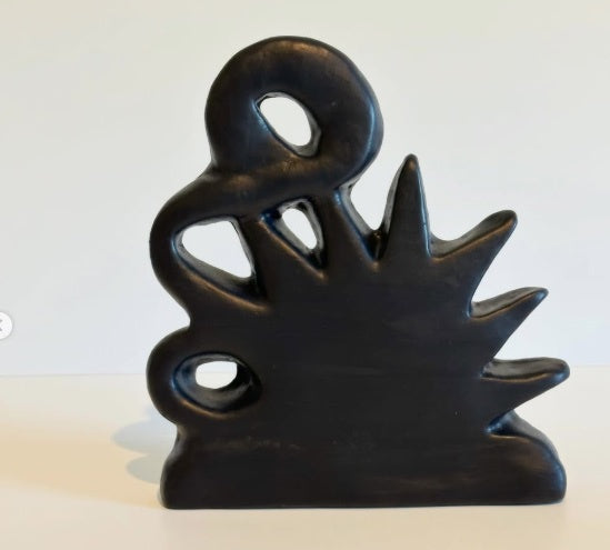 Black abstract sculpture on a white background