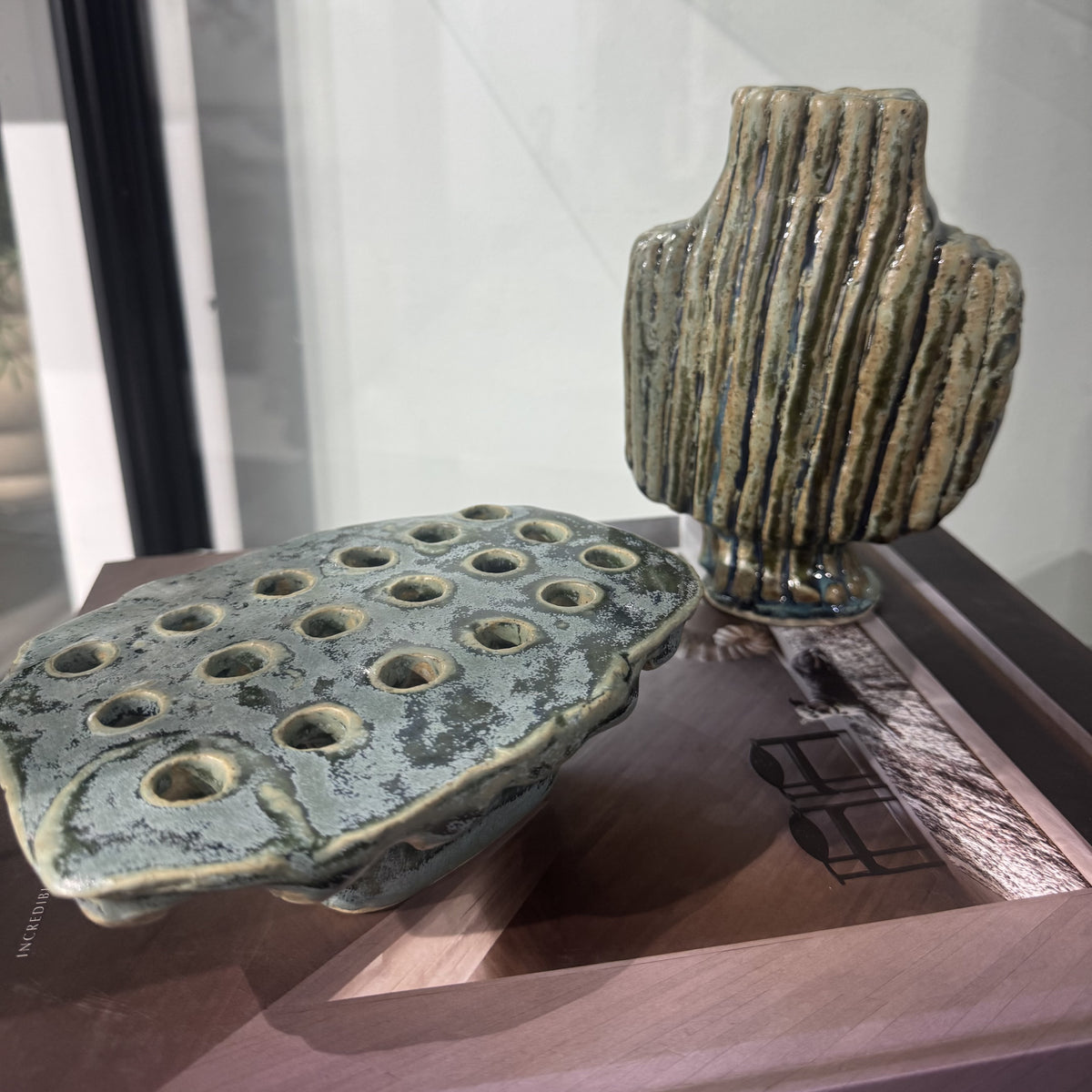 original ceramic footed vessel glazed in green tones with perferrated holes on the surface